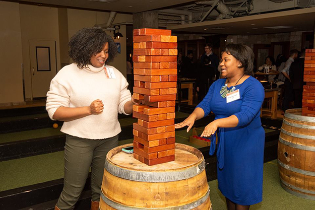 Two party guests play giant jenga.